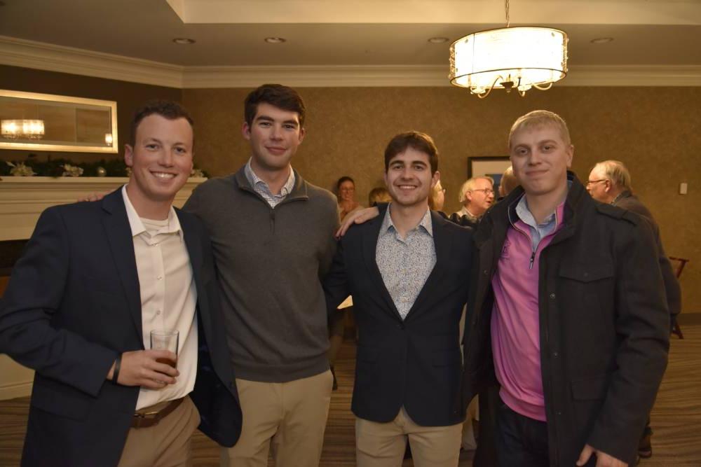 Four Seidman alumni smiling together.